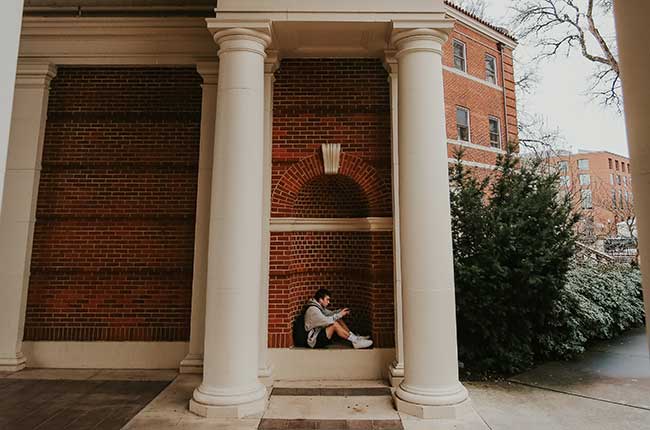 person sitting in a brick inset of Weatherford Hall