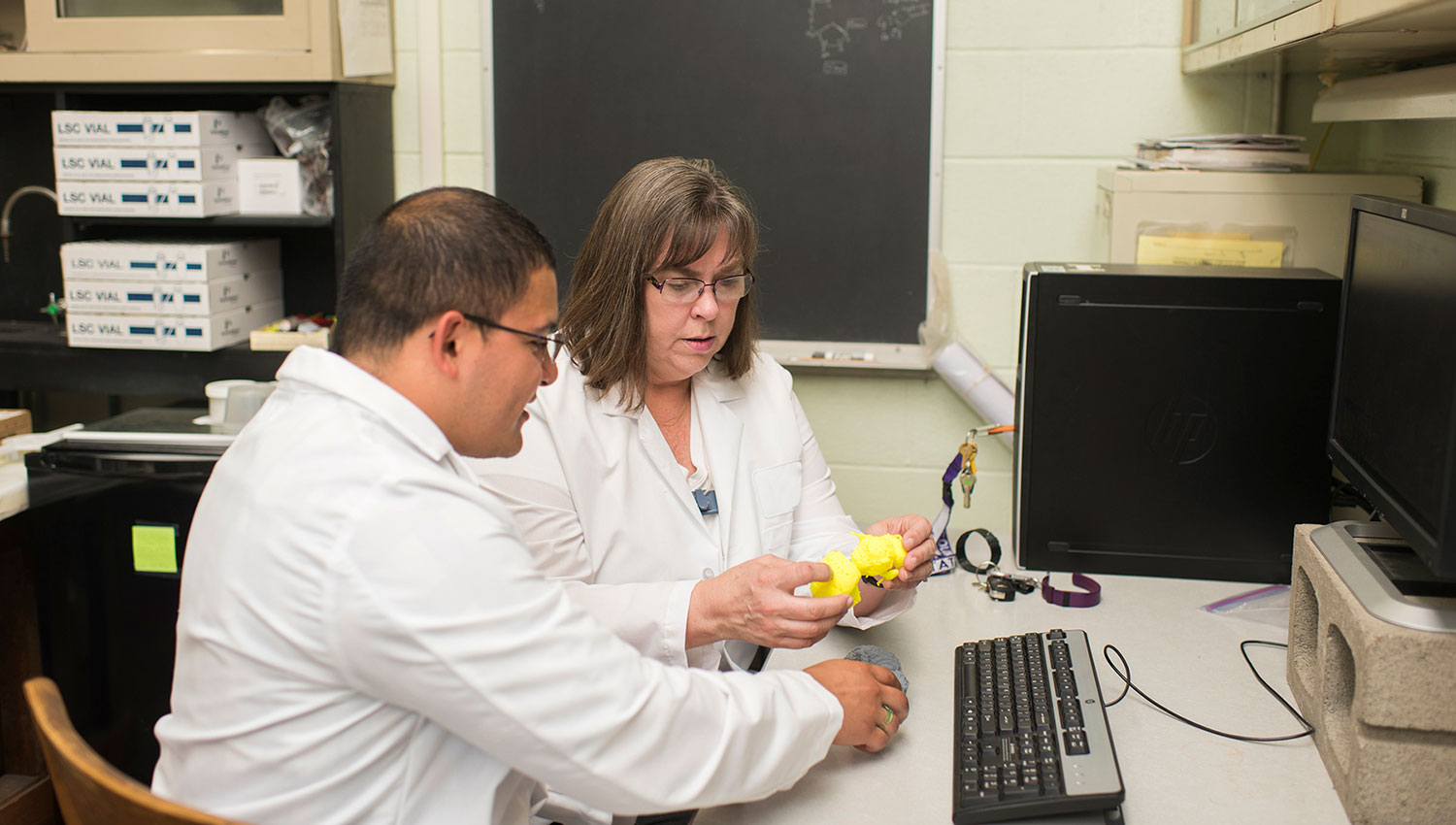 2 lab scientists examining 3d model