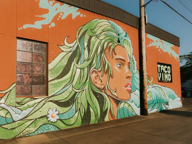 mural of woman with green hair that transitions into ocean waves
