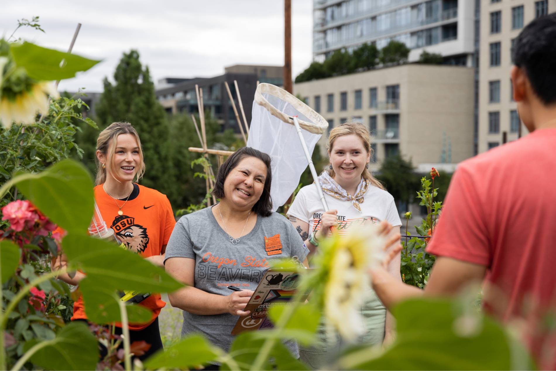 three community gardeners show production staff harvested vegetables