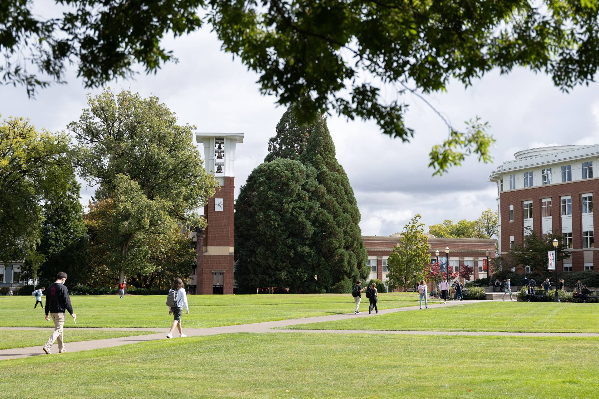people walking across the Valley Library quad with the bell tower in the background