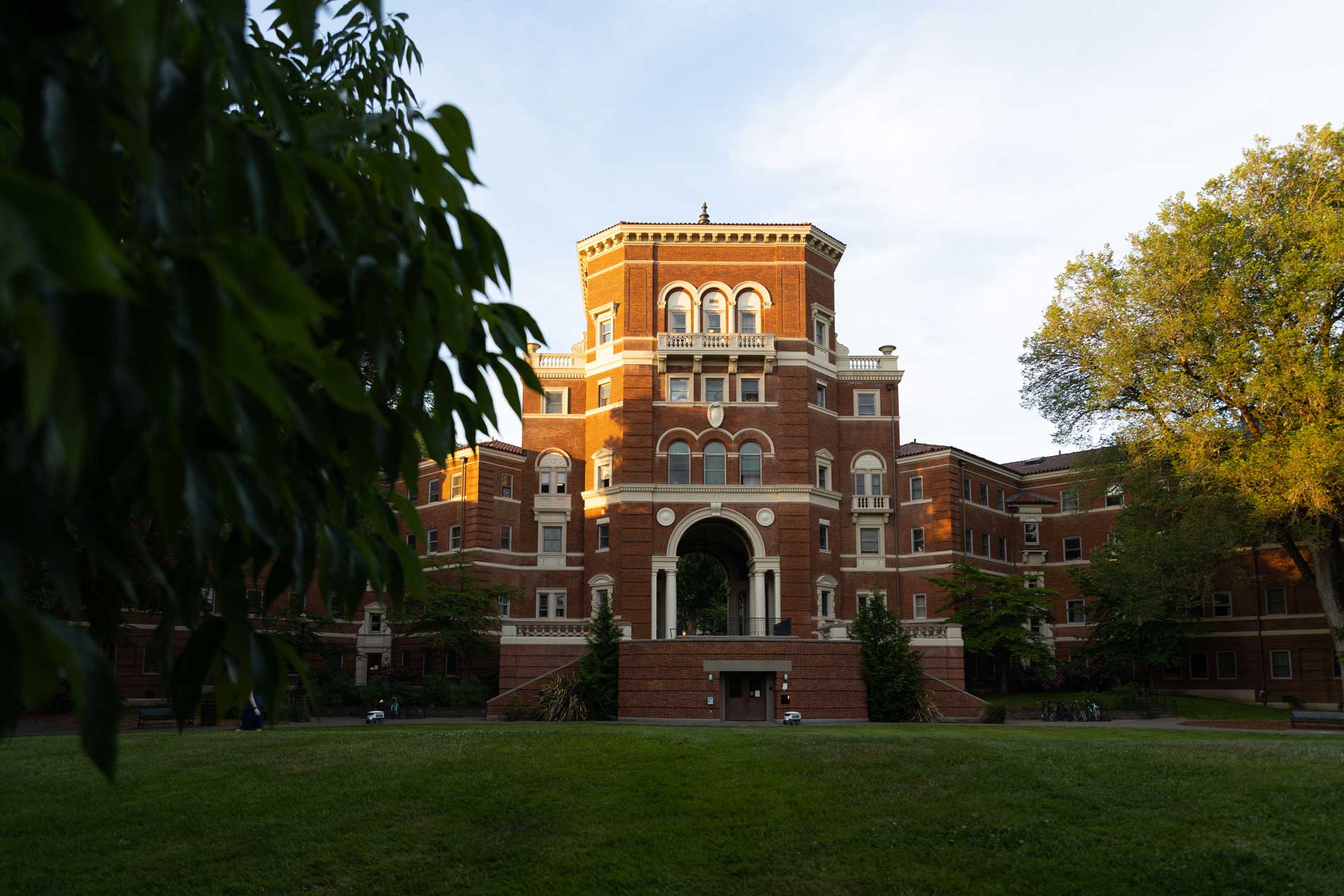 brick 3 story building with an arched walkway through the middle of the building