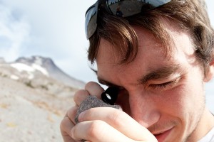 person examining rock on Mt. Hood