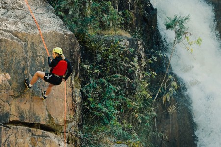 Climber rappelling down cliff