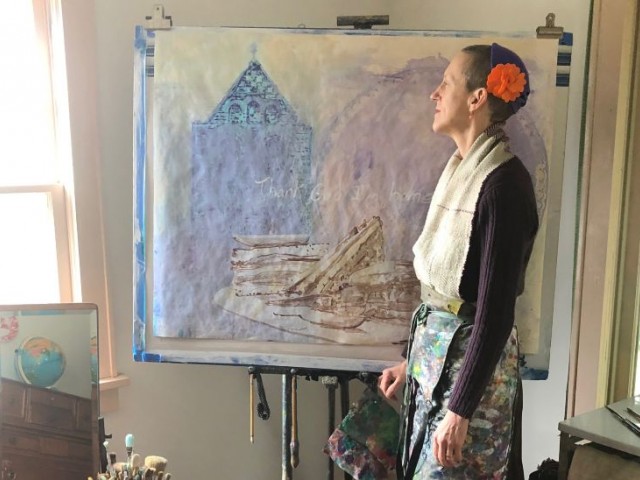 Julie Green, artist, standing in front of her easel